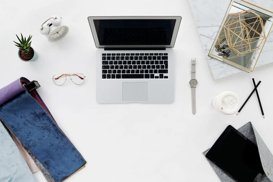 Vue en plongée d’un bureau de travail élégant avec deux écrans, un clavier, une souris et des accessoires modernes.