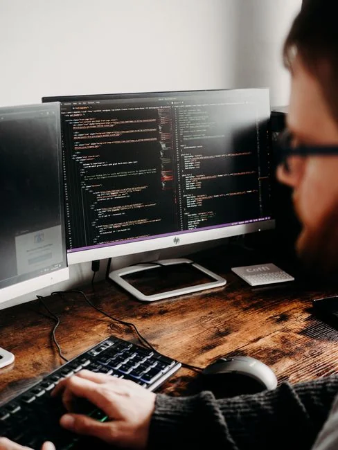 Un bureau de travail élégant et épuré mettant en avant des appareils Apple : iMac, MacBook et iPad.